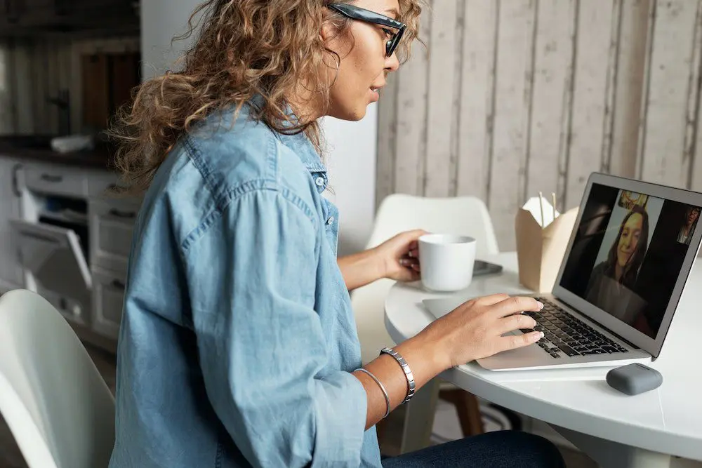 A woman sitting at a table with a laptop.