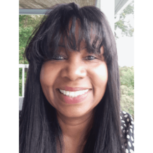 A woman with long black hair smiles for the camera.