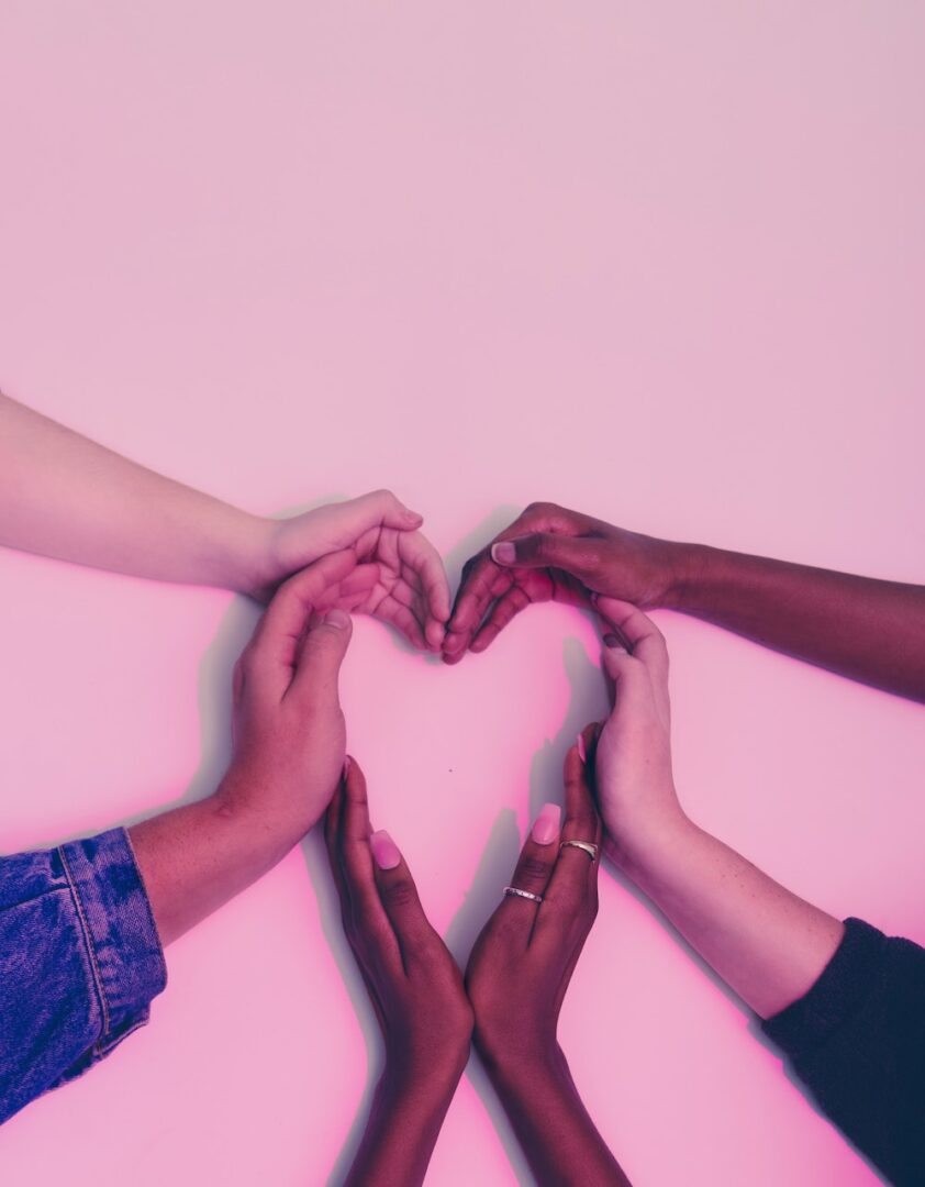 A group of people making heart with their hands.