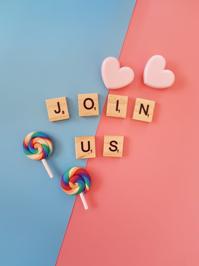A pink and blue background with wooden letters that say " join us ".