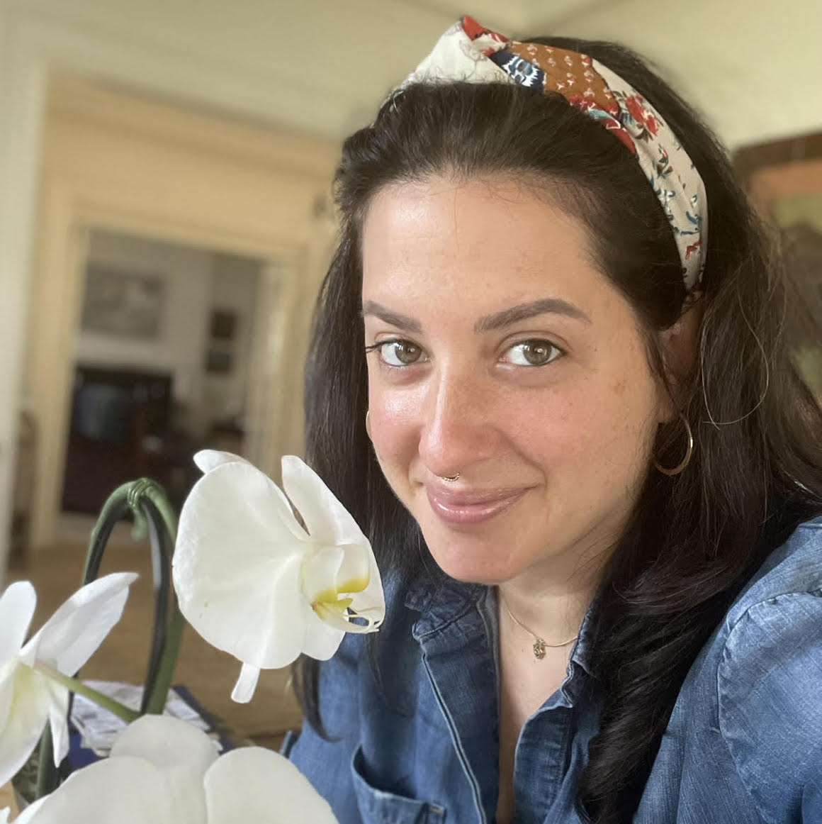 A woman with a headband on holding flowers.